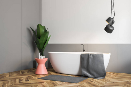 极简主义的浴室角落，白色和灰色的墙壁，木制地板，白色浴缸，上面有灰色毛巾和粉红色的椅子。盆栽植物。3D渲染