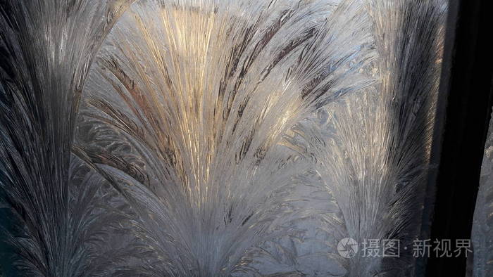 冬天黎明时窗户上美丽的霜花图案. 冰冻的窗户玻璃早晨窗户上的霜图