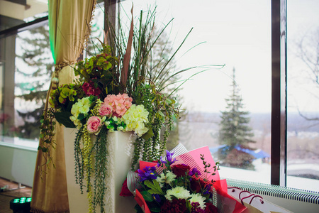 束美丽的鲜艳的花朵在木桌上的篮子里