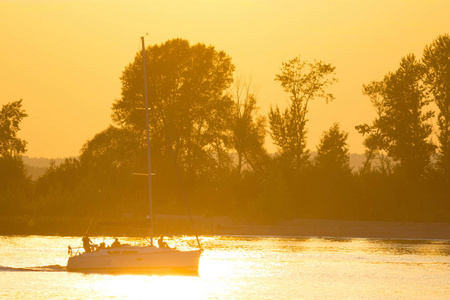 美丽的日落。 遥远的帆船。 在河上航行
