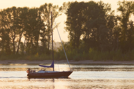 美丽的日落。 遥远的帆船。 在河上航行