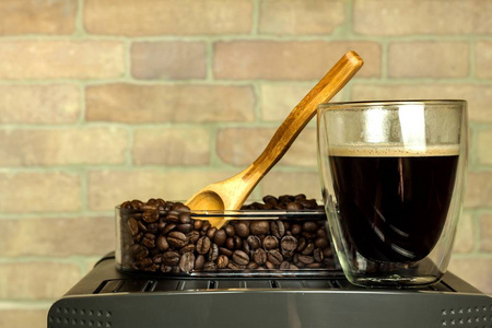 家庭专业咖啡机与浓缩咖啡杯。 咖啡准备。 咖啡机和咖啡豆。