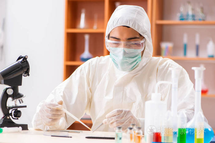 在实验室里穿着防护服工作的年轻生物化学家