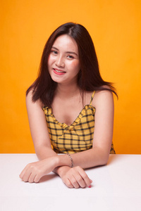 黄色背景下美丽的年轻亚洲女人的肖像