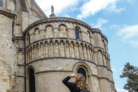一位游客仔细观察了英格兰诺福克诺里奇市中世纪风格天主教大教堂的部分立面。