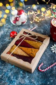 水果帕斯蒂拉水果皮锥在礼品盒和杯可可与棉花糖在圣诞节的黑暗背景复制空间假日概念。 健康饮食