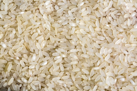 白色背景上分离的一堆生熟大米的顶部视图。 健康的食物。 接近高分辨率产品