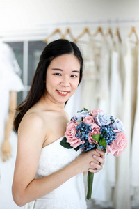 新娘穿着婚纱，捧着一束鲜花和绿色的婚礼理念。