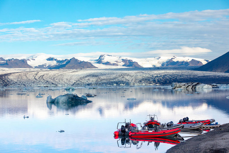 冰岛冰泻湖上的游船。峡湾和冰冰山的阳光霜冻景色
