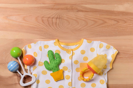 木制背景的婴儿衣服和玩具，俯视图