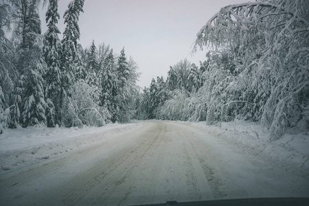 冬天的乡间冰雪覆盖的道路，轮胎痕迹复古的外观