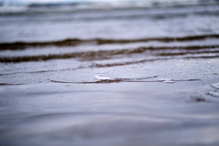 海上的风暴云。 干净的白色沙滩上的小波浪。 浅场深