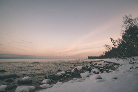 冰封的海边海滩全景在冬天，晚上有很多冰雪复古的外观