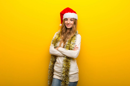 女孩在黄色背景下庆祝圣诞节，手臂交叉在正面位置