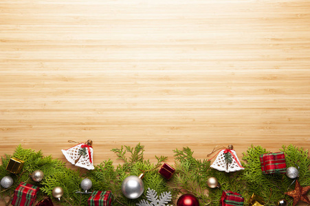 顶部的圣诞背景模板与装饰球礼品盒白色铃铛在杉树上与木制背景与复制空间装饰新年问候。