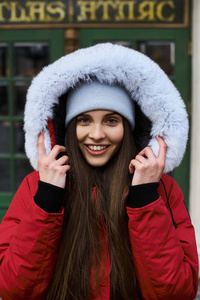 一个年轻时尚的女孩在冬天走在城市的街道上的肖像。