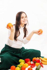 带着蔬菜和水果的微笑的年轻女子白色背景