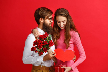 s day concept. happy young couple with heart, flowers, gift on r