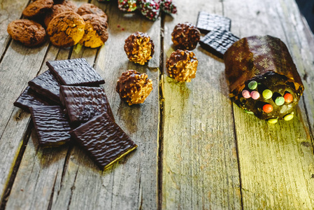 漂亮的构图，带有温暖的圣诞糖果和巧克力饼干的节日背景，布置在乡村的木制桌子上