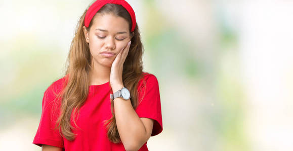 年轻漂亮的黑发女人穿着红色的t恤，在孤立的背景下思考，看起来疲惫，厌倦了交叉双臂的抑郁问题。