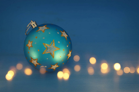 在蓝色背景前用金色星星装饰圣诞树球的形象