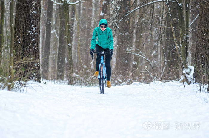 冬天骑自行车的人在雪地森林里骑自行车冬季户外运动概念
