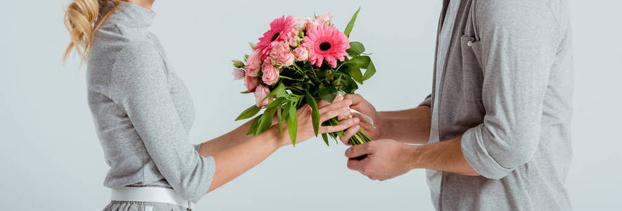 男人把粉红色的花束送给灰色的女人