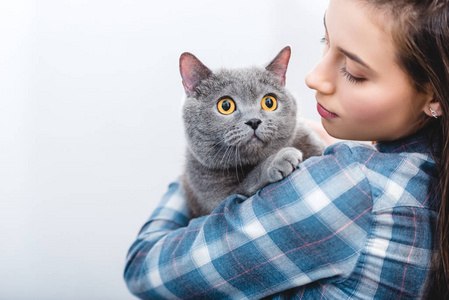 年轻女子抱着漂亮的灰色英国短毛猫