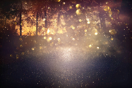 模糊的抽象照片在树木之间爆发，闪闪发光的金色波克灯