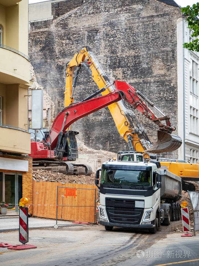挖机拆除房屋重建在柏林德国. 拆除旧建筑物的墙壁,用