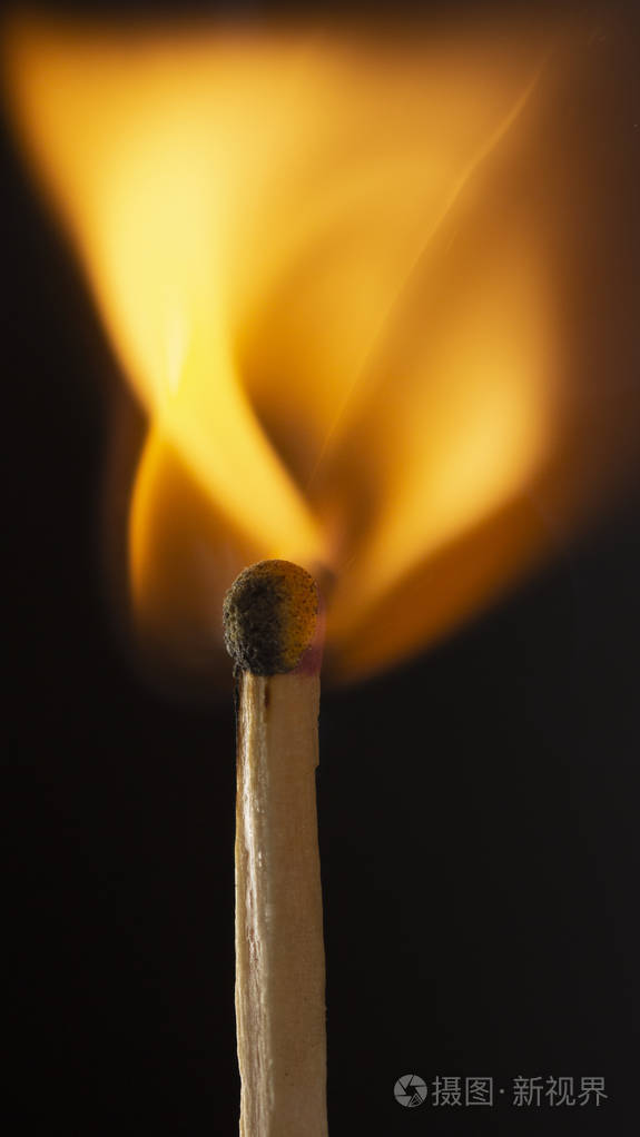 燃烧的木制火柴,黑色背景上有一个红色的火柴头 近点