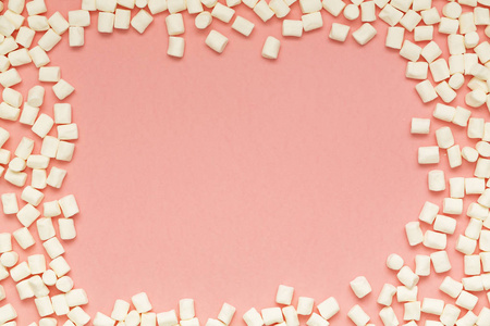 棉花糖在粉红色背景和复制空间。 平躺或俯视。 彩色迷你棉花糖的背景或质地。 冬季食品背景概念。