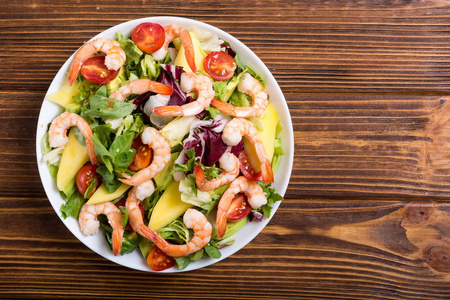 沙拉和虾牛油果和樱桃番茄混合。 健康食品背景