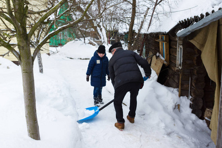 男孩冬天用大铲子清雪