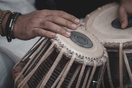 s hands wearing beads playing the Tabla  Indian classical mus