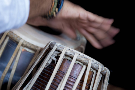 s hands wearing beads playing the Tabla  Indian classical mus