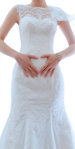 新娘身穿白色婚纱，白色背景，手握心形。