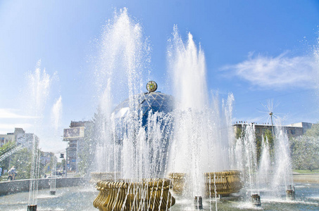一个美丽的喷泉，有喷气式飞机的节奏，一个游泳池和一个水箱收集水和一个边境在夏季下午的城市背景。
