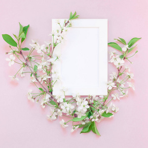 方形平躺概念顶部视图空白框架模拟和樱桃树花在千禧粉红色背景与复制空间在最小风格模板的文字或您的设计。