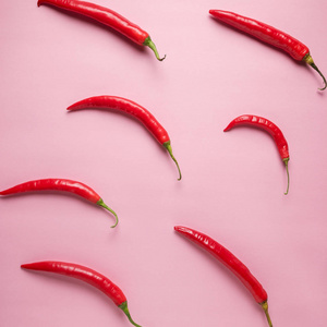 辣椒在粉红色背景上的创意布局。 最小的食物概念。