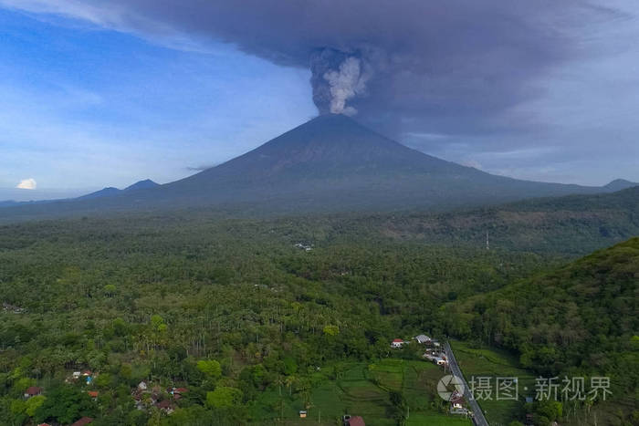 火山灰从火山中升起热带丛林火山脚下的村庄