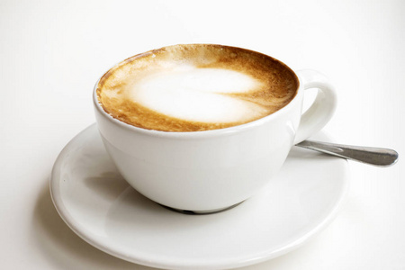 热拿铁与艺术牛奶泡沫在咖啡杯上的白色桌子。