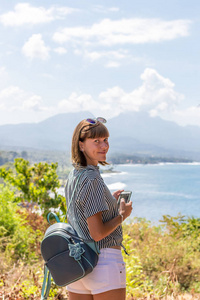 背着背包站在山崖上的女人。巴厘岛