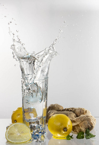 一杯柠檬水放在浅色背景上，溅起水来