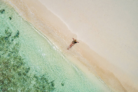 空中无人机鸟瞰美丽的女孩在阳光明媚的热带海滩上玩得开心。塞舌尔