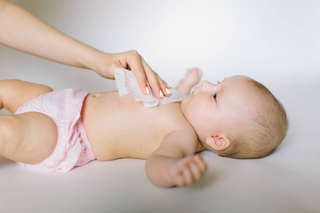 卫生年轻妈妈用湿巾擦拭婴儿皮肤。 清洁，清洁