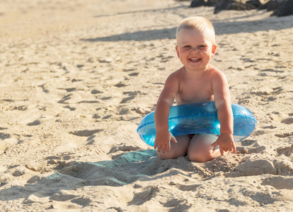 快乐的小男孩在阳光明媚的海滩上游泳