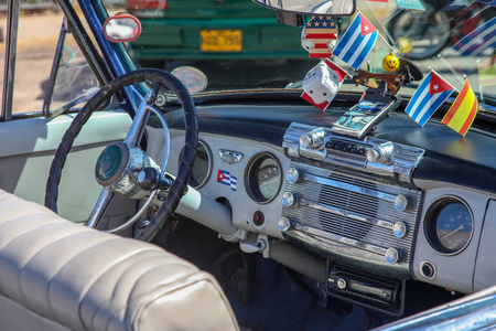 关闭一个经典复古老式汽车的内部美国梦1950年代方向盘时钟仪表板速度计。户外。