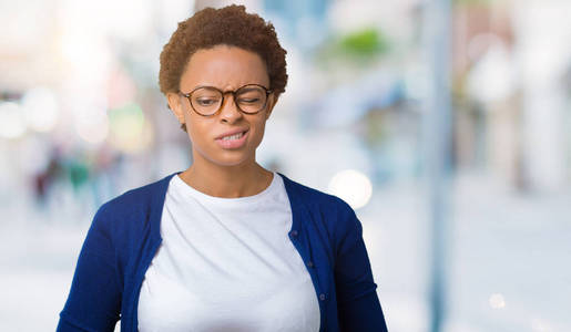 年轻美丽的非裔美国妇女戴着眼镜，戴着孤立的背景，手放在肚子上，因为消化不良，痛苦的疾病，感觉不舒服。 疼痛的概念。