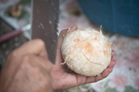 男士在泰国当地市场为顾客切椰子